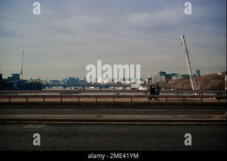 22 Jan 2023 - LondonUK: View of london skyline over blackfriars bridge with no traffic but small group of people walking past on sunny day Stock Photo