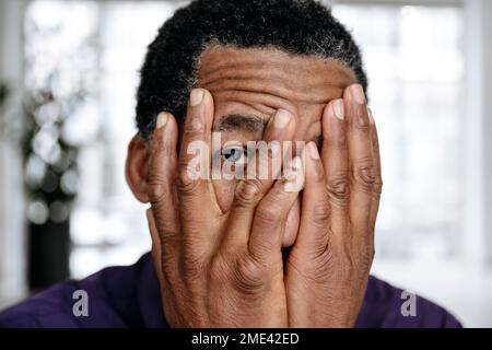 Mature man covering face with hands Stock Photo