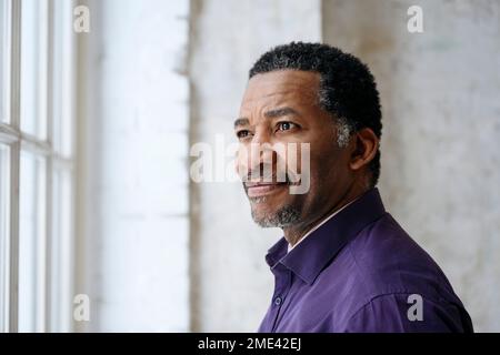 Thoughtful mature man looking out through window Stock Photo