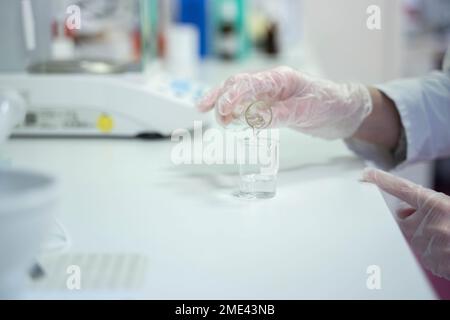 Hand of scientist mixing liquids at laboratory Stock Photo