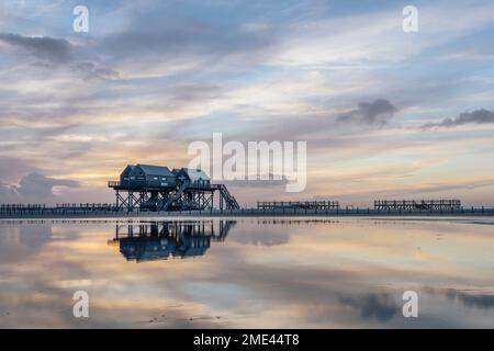 Germany, Schleswig-Holstein, St. Peter-Ording, Clouds over coastal stilt houses at dusk Stock Photo