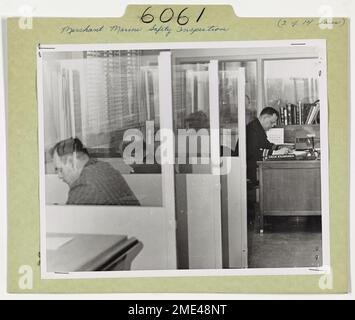 Preventing Sea Disasters in the Coast Guard's Business. To assure that American ships are manned by competent personnel, the Coast Guard examines the professional qualifications of crew members and issues licenses to officers and certifications to seamen. Candidates for merchant marine licenses are shown here in the booths of the Baltimore examination room. Stock Photo