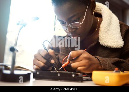 University student, engineering and electronics with black woman learning on electrical project. Education, engineer or technician with technology Stock Photo