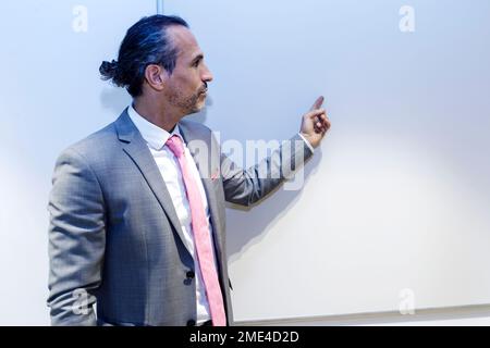 Mature businessman pointing at whiteboard giving speech in conference room at office Stock Photo