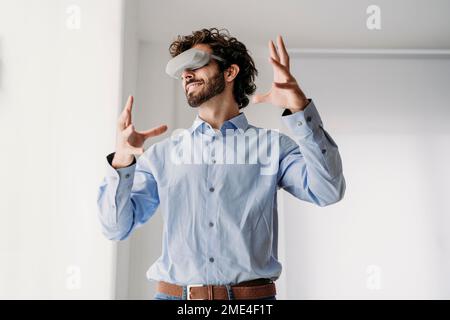 Engineer wearing VR glasses gesturing in office Stock Photo