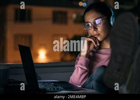 Creative woman, laptop and thinking at night for deadline, project or working late at office. Business woman relaxing by desk in thought for planning Stock Photo