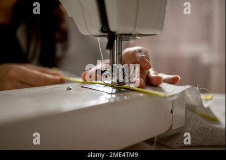 Woman using sewing machine at home Stock Photo