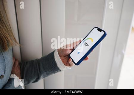 Hand of woman using home automation app on smart phone Stock Photo