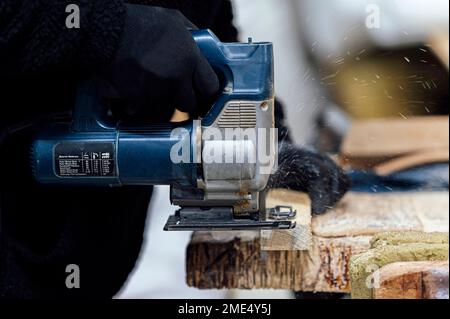 Craftsman using hand saw for cutting wood in workshop Stock Photo