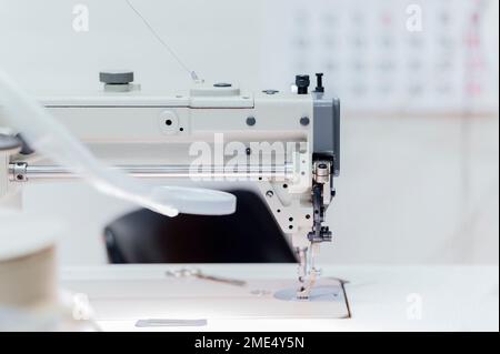 Sewing machine on table in workshop Stock Photo