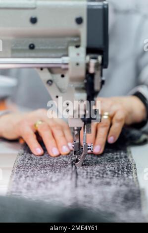 Senior woman using sewing machine in workshop Stock Photo
