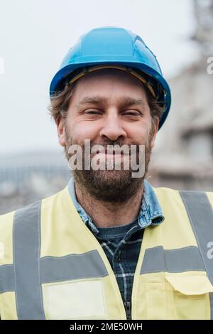 Smiling construction worker wearing hardhat Stock Photo