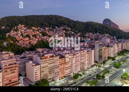 Aerial drone view of Leme neighbourhood in Copacabana with Babilonia favela in the background with Sugarloaf mountain on the right at sunrise, Rio Stock Photo