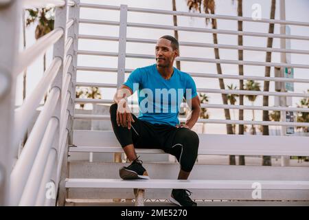 Thoughtful man sitting on steps Stock Photo