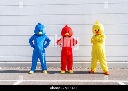 Men and woman wearing duck costumes standing in front of wall Stock Photo