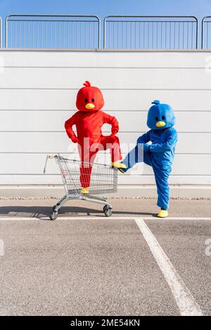 Man and woman wearing duck costumes standing in front of wall Stock Photo
