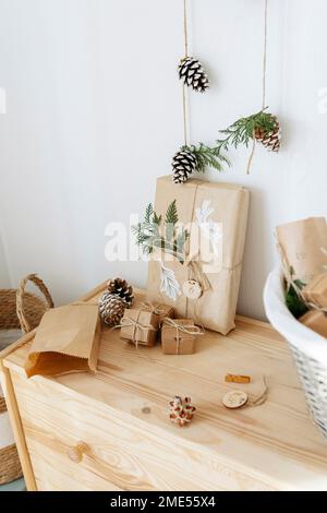 Christmas gift boxes with decorated pine cones kept on cabinet Stock Photo