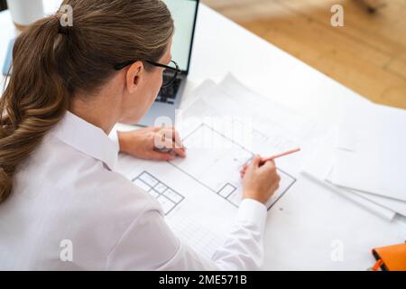 Engineer working on blueprint in office Stock Photo