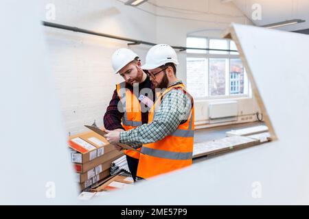 Engineers discussing over document at construction site Stock Photo
