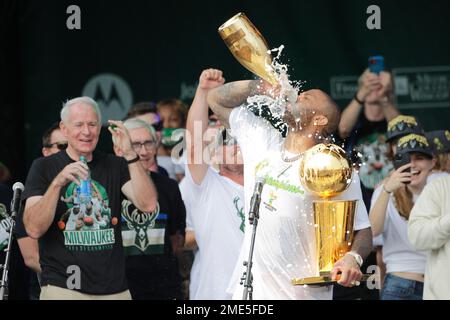 Milwaukee Bucks' P.J. Tucker drinks champagne as he holds