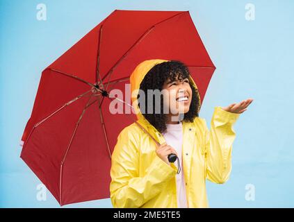 Black woman, umbrella or hand checking for rain on isolated blue background in Brazil city. Person, anxiety or student in weather water drops or Stock Photo
