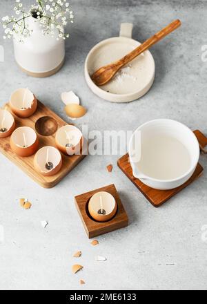 Melt the wax. Natural craft for kids concept. Making trendy DIY candles for Easter from eggshells. Copy space. Stock Photo