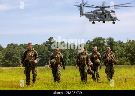 U.S. Marines with Combat Logistics Battalion 24, 2nd Marine Logistics Group, leave the landing zone after completing external lift operations during Hide and Seek Field Exercise on Marine Corps Base Camp Lejeune, North Carolina, July 27, 2022. Hide and Seek is a field exercise hosted by 10th Marines, 2nd Marine Division that trains participants on signature management, communication, electronic warfare, cyberspace operations and intelligence collection, processing and dissemination in order to enable future operations in a multi-domain contested environment. Stock Photo