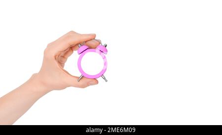 Hand holding beautiful small pink alarm clock isolated on white background. Concept of time. Clock face isolated white as a mock up Stock Photo