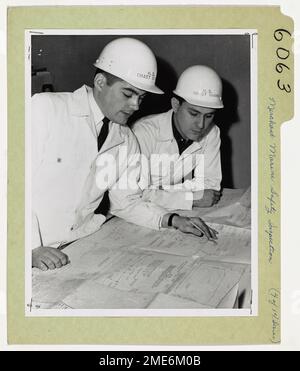 Preventing Sea Disasters in the Coast Guard's Business. Coast Guard marine inspectors, (left) Lieutenant Paul M. Hureau and Lieutenant Joel D. Sipes, study the plans of the newly built Grace Line passenger and cargo ship SS Santa Mercedes before boarding for inspection of her fittings while she is still in dry-dock at the Bethlehem Steel Shipyard at Sparrows Pt., Baltimore, Md. Stock Photo
