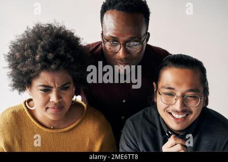 This requires a group effort. a group of young businesspeople sitting and working together in the office during the day. Stock Photo