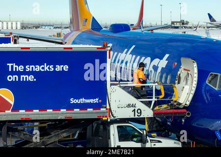 Denver, Colorado - Southwest Airlines jets on the ground after a snowstorm at Denver International Airport. A food service worker loads snacks onto a Stock Photo