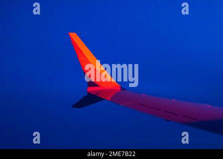 The wing of a Southwest Airlines Boeing 737 MAX jet flying above Nebraska late in the evening. Stock Photo