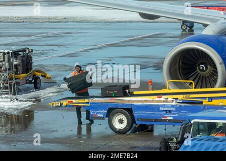 Denver, Colorado - Southwest Airlines jets on the ground after a snowstorm at Denver International Airport. A worker loads baggage onto a departing fl Stock Photo