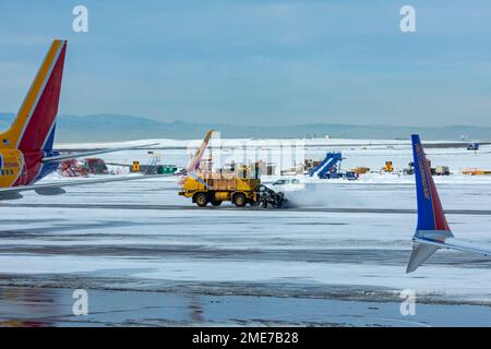 Denver, Colorado - A snowplow clears a taxiway near Southwest Airlines jets at Denver International Airport. Stock Photo