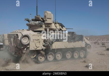 U.S. Soldiers assigned to 5th Squadron, 4th Cavalry Regiment, 2nd Armored Brigade Combat Team, 1st Infantry Division maneuver an M2 Bradley over terrain during Decisive Action Rotation 22-09 at the National Training Center, Fort Irwin, Calif., Aug. 14th, 2022 Stock Photo