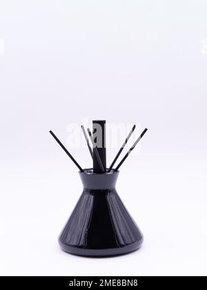 Wooden aroma sticks in a glass flask filled with flavor liquid substance isolated over white background, side view  Stock Photo
