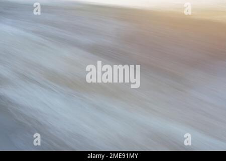 Dynamic texture of fast moving water, in pastel pale neutral tones. Concepts of nature and motion. Stock Photo