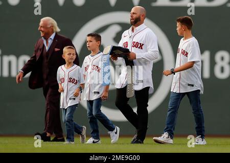 Former Boston Red Sox's Dustin Pedroia, right, walks off the field with his  family and former player Pedro Martinez, left, after ceremonies in  Pedroia's honor before a baseball game against the New