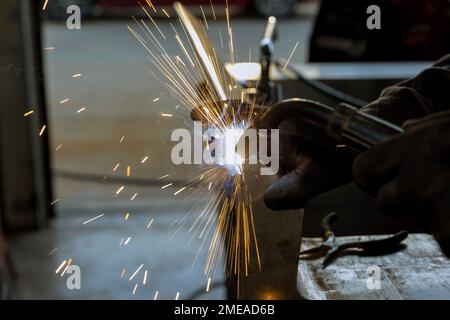 Using semi-automatic argon gas shielded welding machine worker is welding metal Stock Photo
