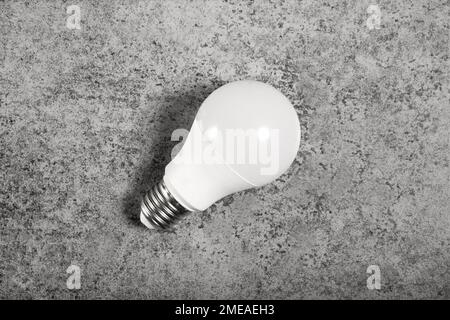 Simple standart form LED energy-saving lamp with E27 screw cap base on gray background Stock Photo