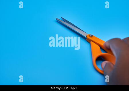 Orange shear scissors on a light blue background cutting shears baby blue Stock Photo