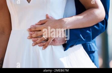 Hands, married and interracial wedding of couple for outdoor celebration of partnership, care and love. Marriage commitment and support of bride with Stock Photo