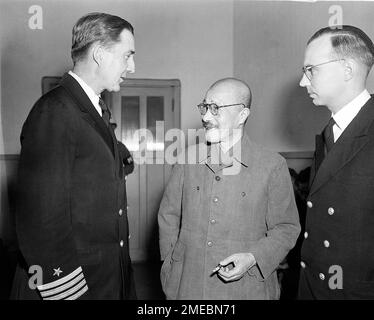 Capt. Beverly M. Coleman, left, of Wash., D.C., and Lieut. Valentine B. Deale, right, of Cleveland, both of the American defense staff at the War Crimes Trials in Tokyo, chat with former Japanese prime minister and military leader Hideki Tojo, on trial for war crimes, as they discuss the defense at the opening of the trials, May 3, 1946. (AP Photo/Charles Gorry)