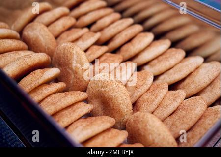Closeup of freshly baked Snickerdoodles (sugar cookies coated with sugar and cinnamon) in a cookie tin. Stock Photo