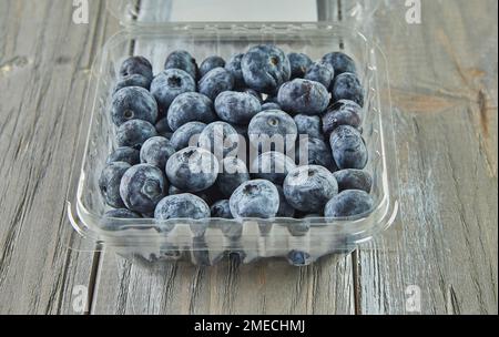 Box with selected blueberries on wooden background Stock Photo