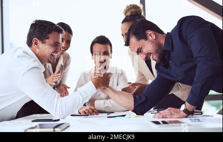 Its all in the name of fun and games. two businessmen arm wrestling in an office. Stock Photo