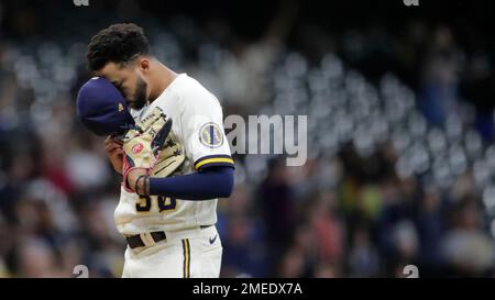 Milwaukee Brewers' Devin Williams hands his glove to an umpire during the  eighth inning of a baseball game against the New York Mets Sunday, Sept.  26, 2021, in Milwaukee. The Brewers defeated