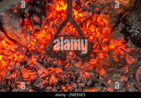 Heating branding iron for cattle over embers. Selective focus Stock Photo