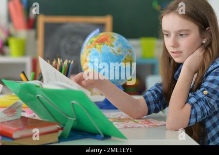 cute girl doing home work at desk Stock Photo