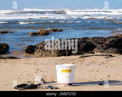 tools for shellfish gathering on the coast with blue sea waves in the background Stock Photo